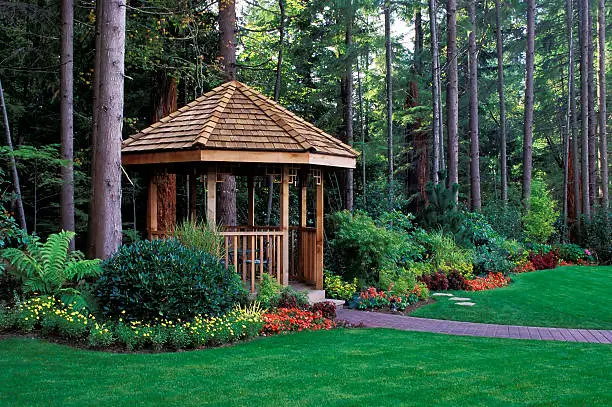 Elegant white garden gazebo with seating, set within lush landscaped greenery at Grace Meadows