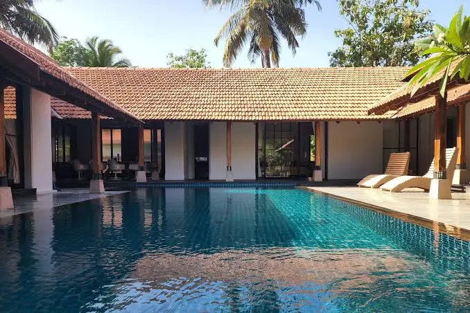 Poolside seating area surrounded by tropical greenery at the Grace Meadows swimming pool